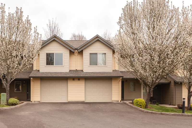 Roberts Court Townhomes exterior with attached garages and blooming trees in Gresham, Oregon