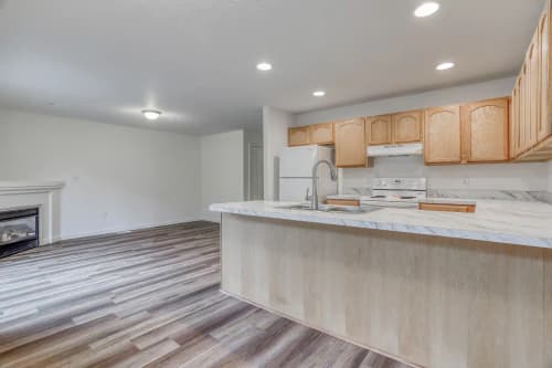 Modern kitchen with stainless steel appliances, white cabinets, and granite countertops
